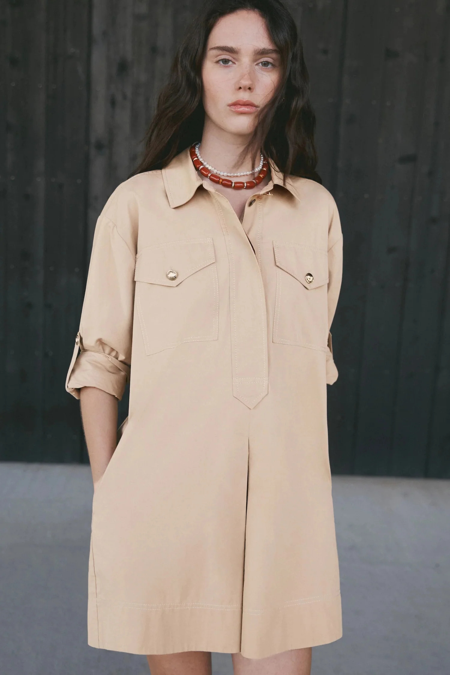Woman wearing a beige dress with a dark background