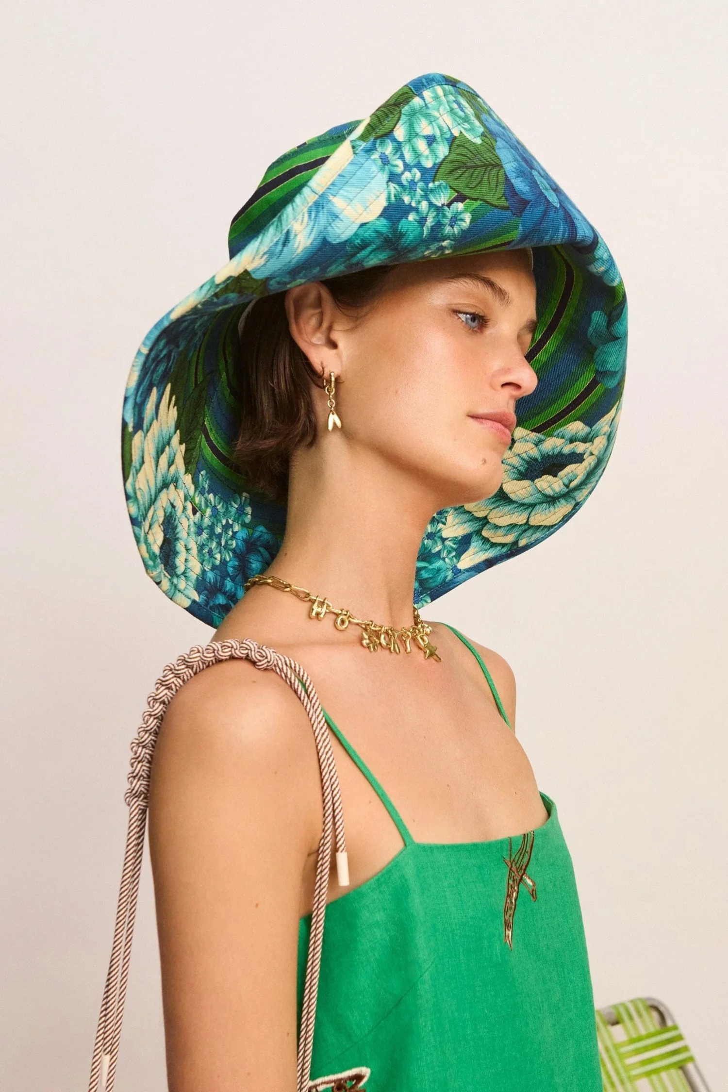 Woman wearing a colorful floral hat with a neutral background