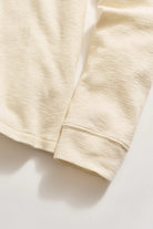 close up of long sleeved slub tuck henley in tinted white-novaman